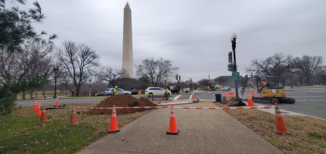 Workers doing construction at a crosswalk near the National Mall.