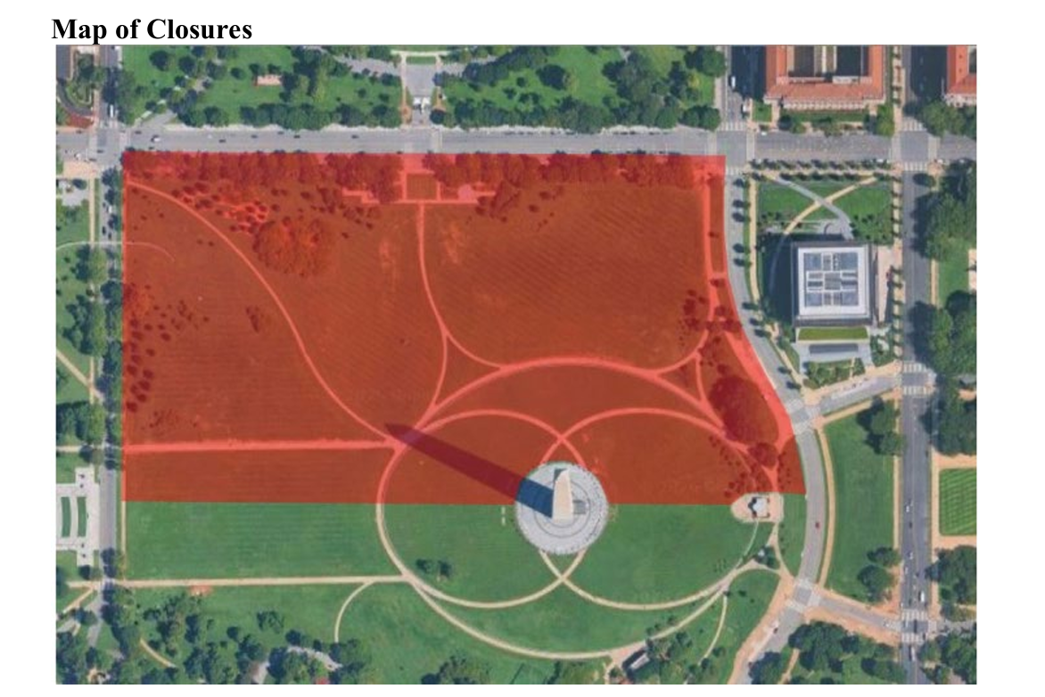 A shaded red polygon overlaps an aerial view of a large green lawn with roads and a few buildings beyond the lawn's border.