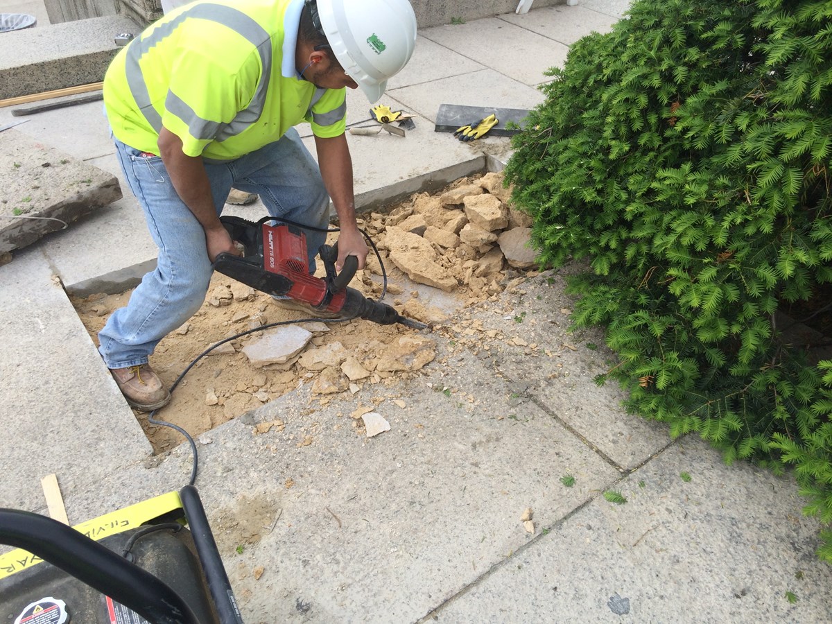 Construction worker using Jackhammer in repair of sidewalk