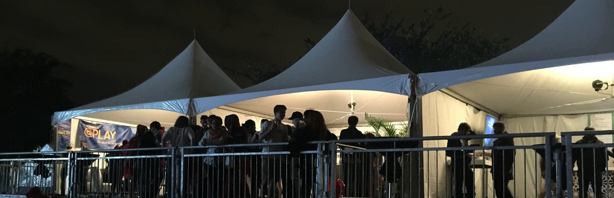 People standing in a large event tent at night