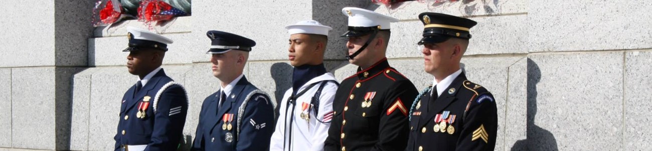 Five members of the US military lined up at a memorial