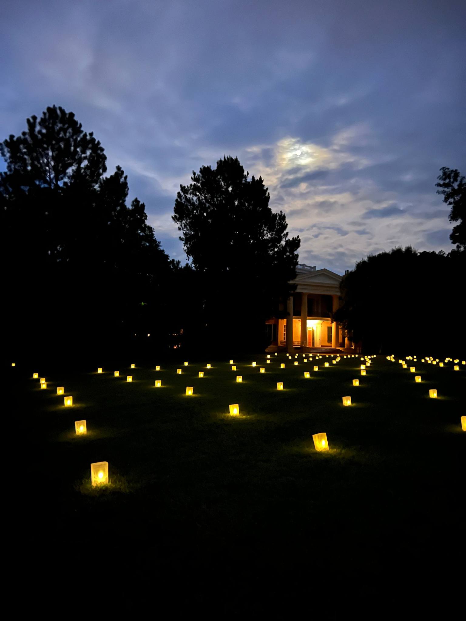 illuminated candles on a hilly lawn