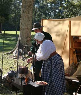 Visitors talk with members of the Tombigbee Pioneer Group at their encampment. Visitors talk with members of the Tombigbee Pioneer Group at their encampment.