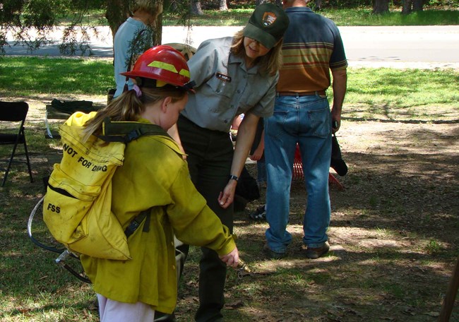 A Junior Ranger wears the fire gear during a special program. A Junior Ranger wears the fire gear during a special program.