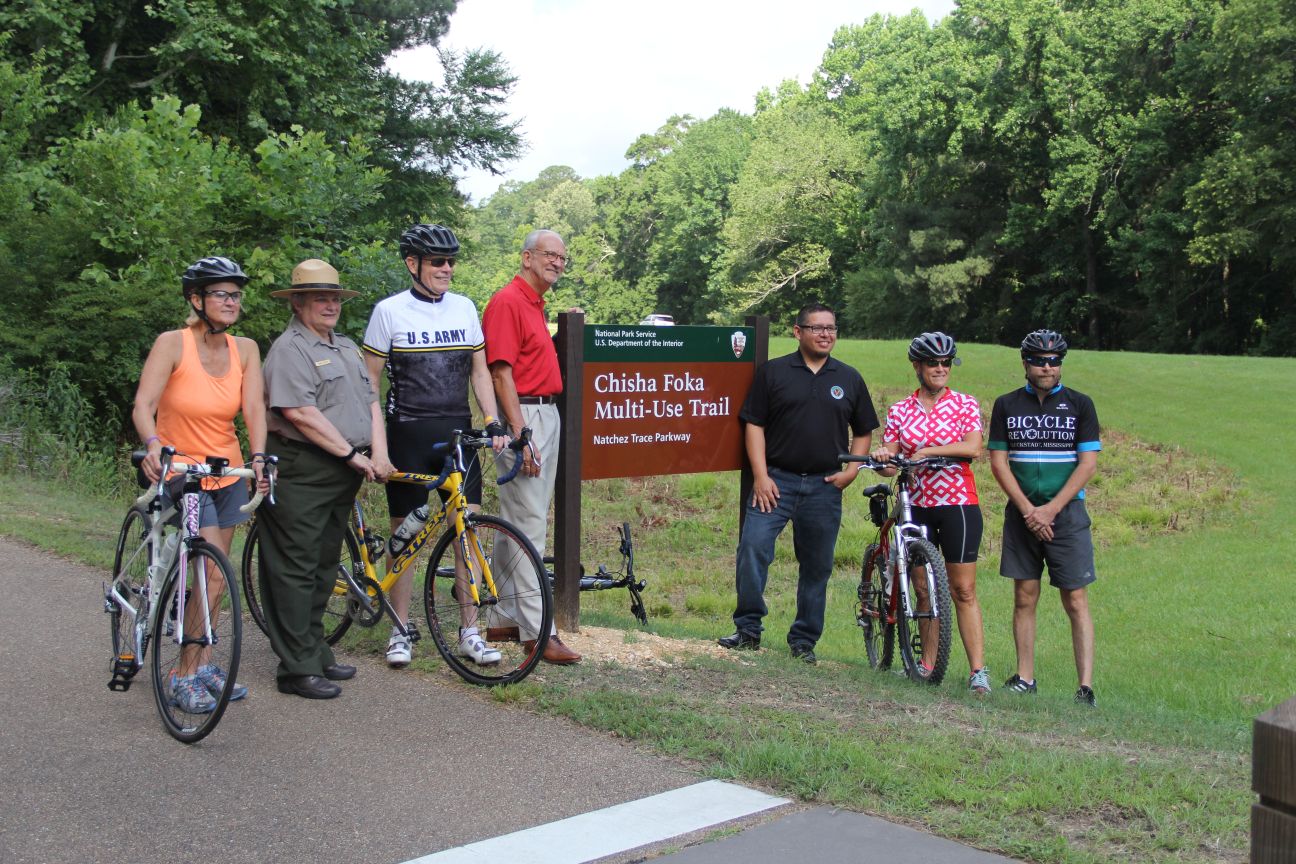 Superintendent Mary Risser joins Choctaw Nation of Oklahoma representative Joseph Wolf, Ridgeland Mayor Gene McGee, and area bicyclists for the Chisha Foka Multi-Use Trail sign dedication. Superintendent Mary Risser joins Choctaw Nation of Oklahoma representative Joseph Wolf, Ridgeland Mayor Gene McGee, and area bicyclists for the Chisha Foka Multi-Use Trail sign dedication.