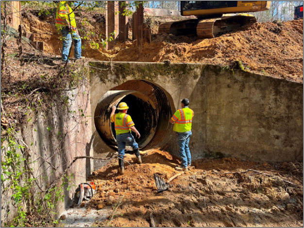 Replacing a failed culvert on the Natchez Trace Parkway Two men stand outside a large culvert under construction