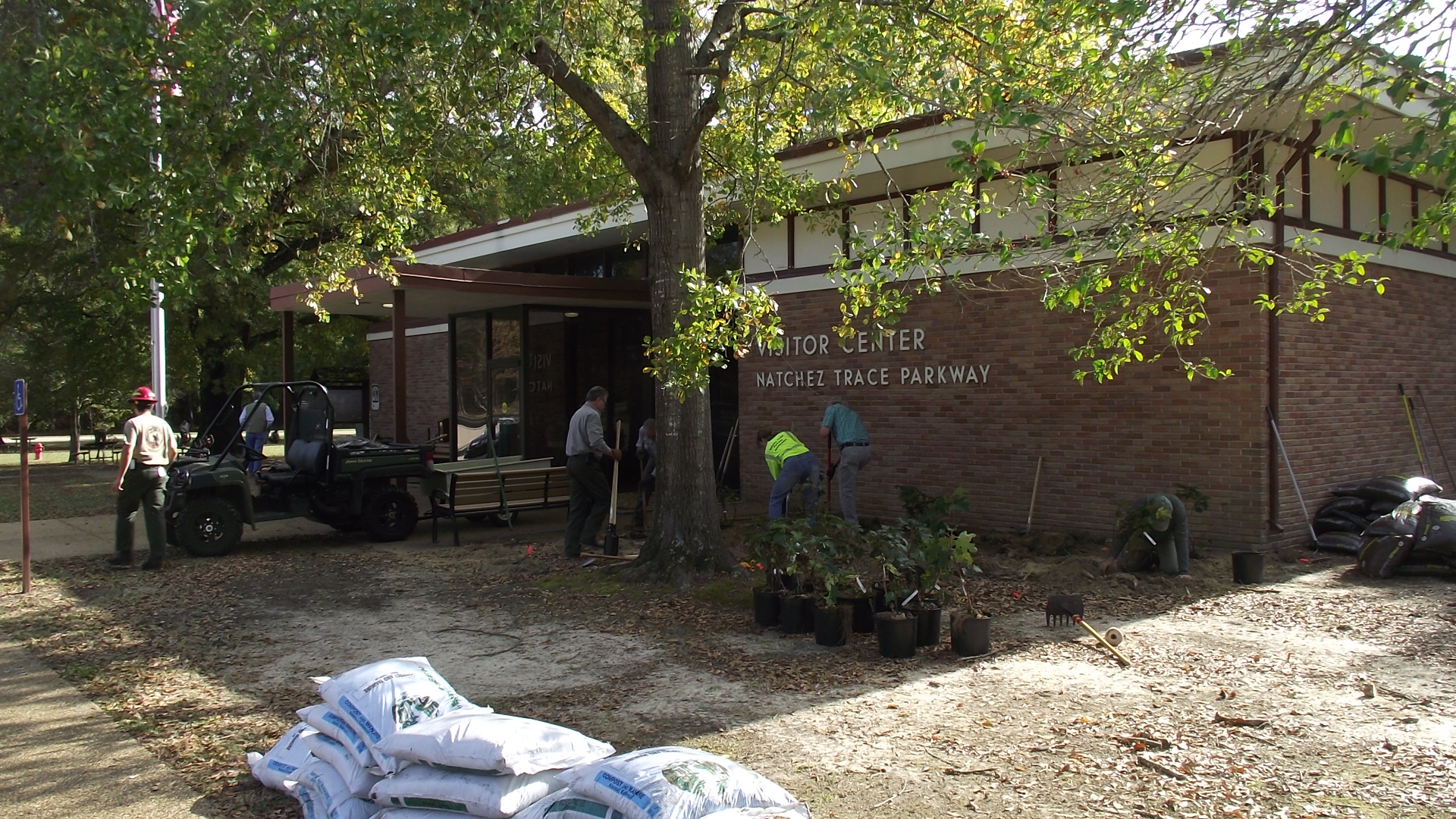 fove park rangers in front of visitor center planting small shrubs