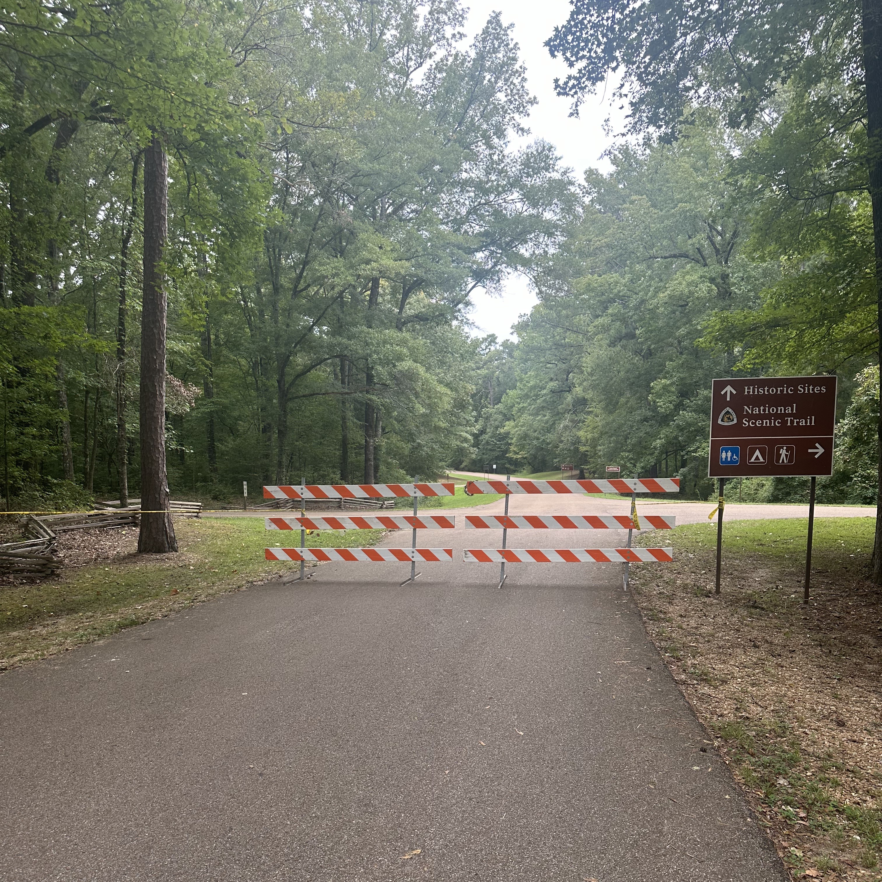 barricades_rockysprings 2024 Barricades block the roadway, leading to a wooded area.