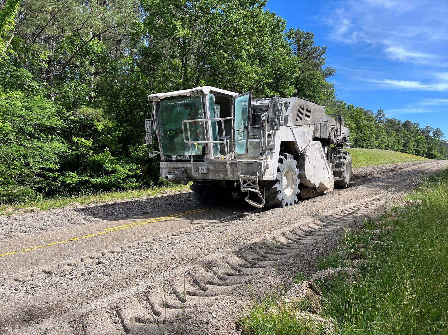 Reclaimer Vehicle A large construction vehicle with a square glass cab, large wheels, and a metal vented box-like shaped rear.