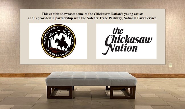 A photo of a wall in an art gallery displaying the logos of the Natchez Trace Parkway and the Chickasaw Nation