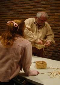 A visitor learns to make a basket with a demonstrator from the Tombigbee Pioneer Group. A visitor learns to make a basket with a demonstrator from the Tombigbee Pioneer Group.