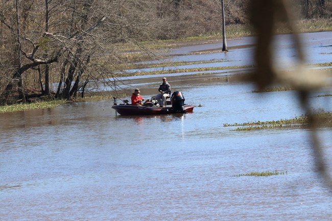 Two people in a boat with fishing poles