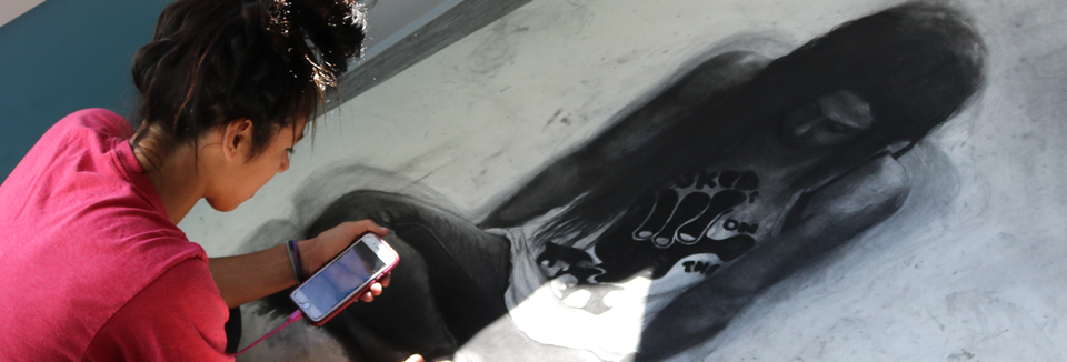 Amy Araujo Artist-In-Residence Amy drawing in charcoal on a canvas