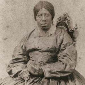 Anna Murray -300 Sepia photo of Anna Murray, middle aged, sitting in a heavy dress.