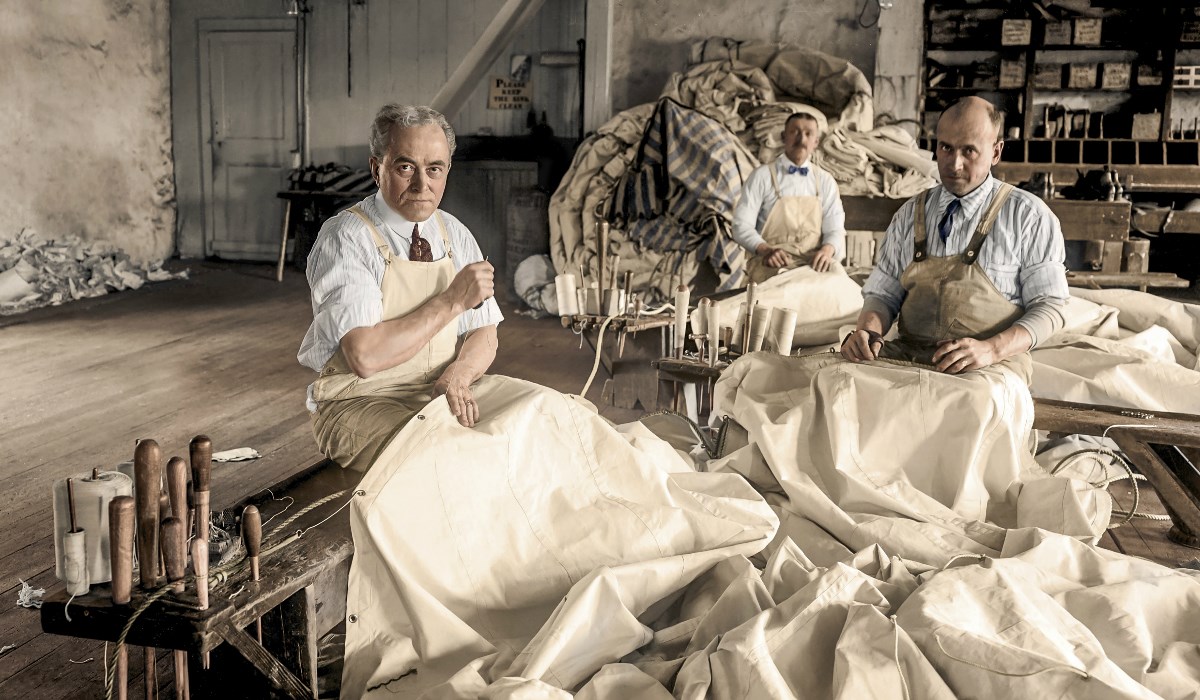 Colorized image of three men sewing sails during whaling error.