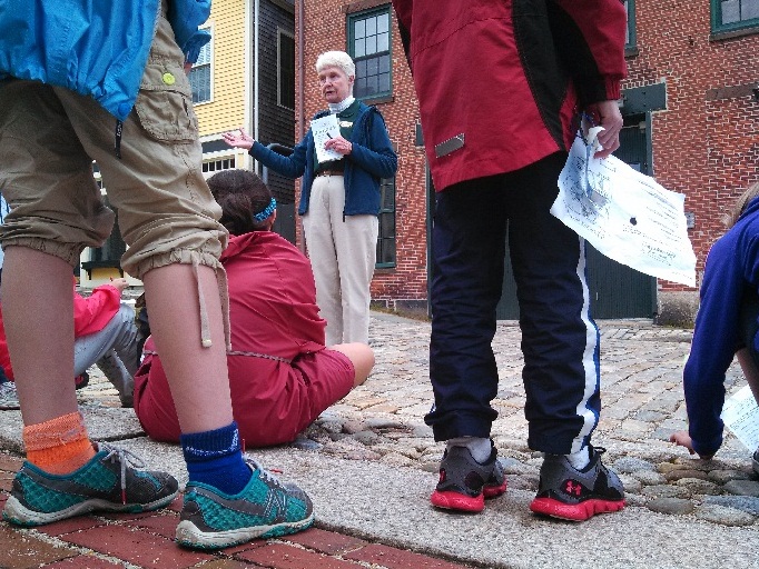 Volunteer leads a group of children on a walking tour.