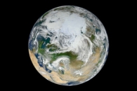 Image of earth from space. Swirling clouds cover land masses and oceans.
