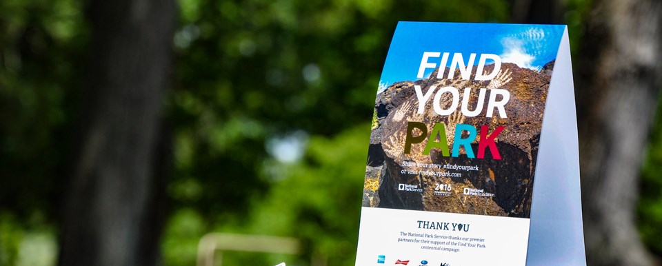 Find Your Park tent card with a blurred green background