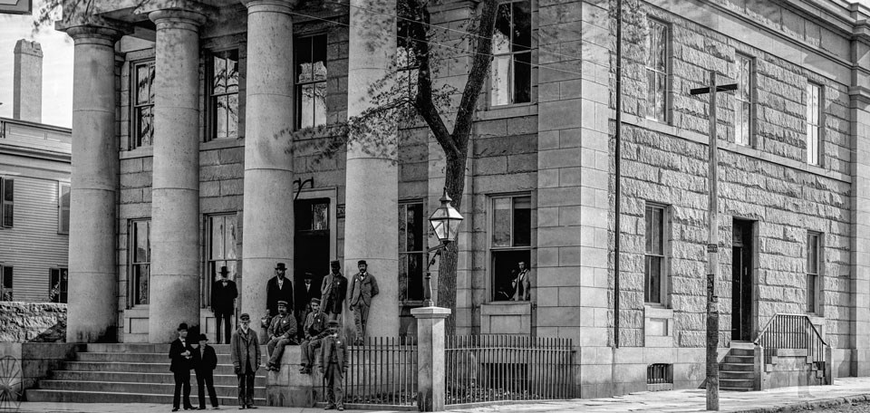 Historic photo of sostal service men standing in from of the U.S. custom house
