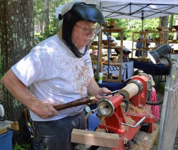 a man works with a lathe to create items made of wood