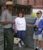 A ranger with a couple of visitors in front of the park visitor center.