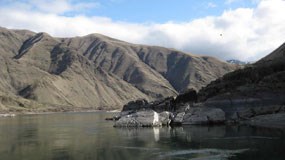 A river surrounded by rocky cliffs and the mountains in the background. A river surrounded by rocky cliffs and the mountains in the background.