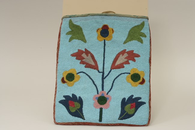 Large beaded bag with blue background and floral patterns