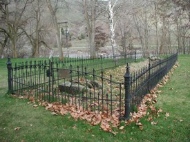 The remains of the mission's foundation surrounded by a black iron fence.