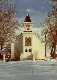 A white chapel during winter time with snow on the ground. A white chapel during winter time with snow on the ground.