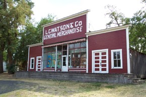 A red and white store front with the sign "L.C Watsons & Co General Merchandise." A red and white store front with the sign "L.C Watsons & Co General Merchandise."