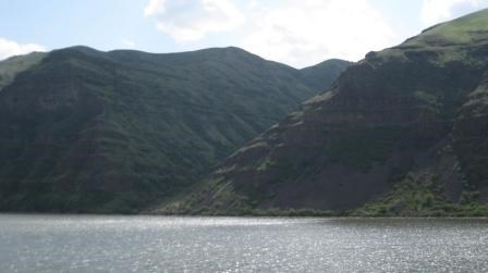 A river next to the mountains on a sunny day.