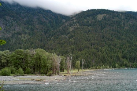 A lake with the mountains in the background on a cloudy day.