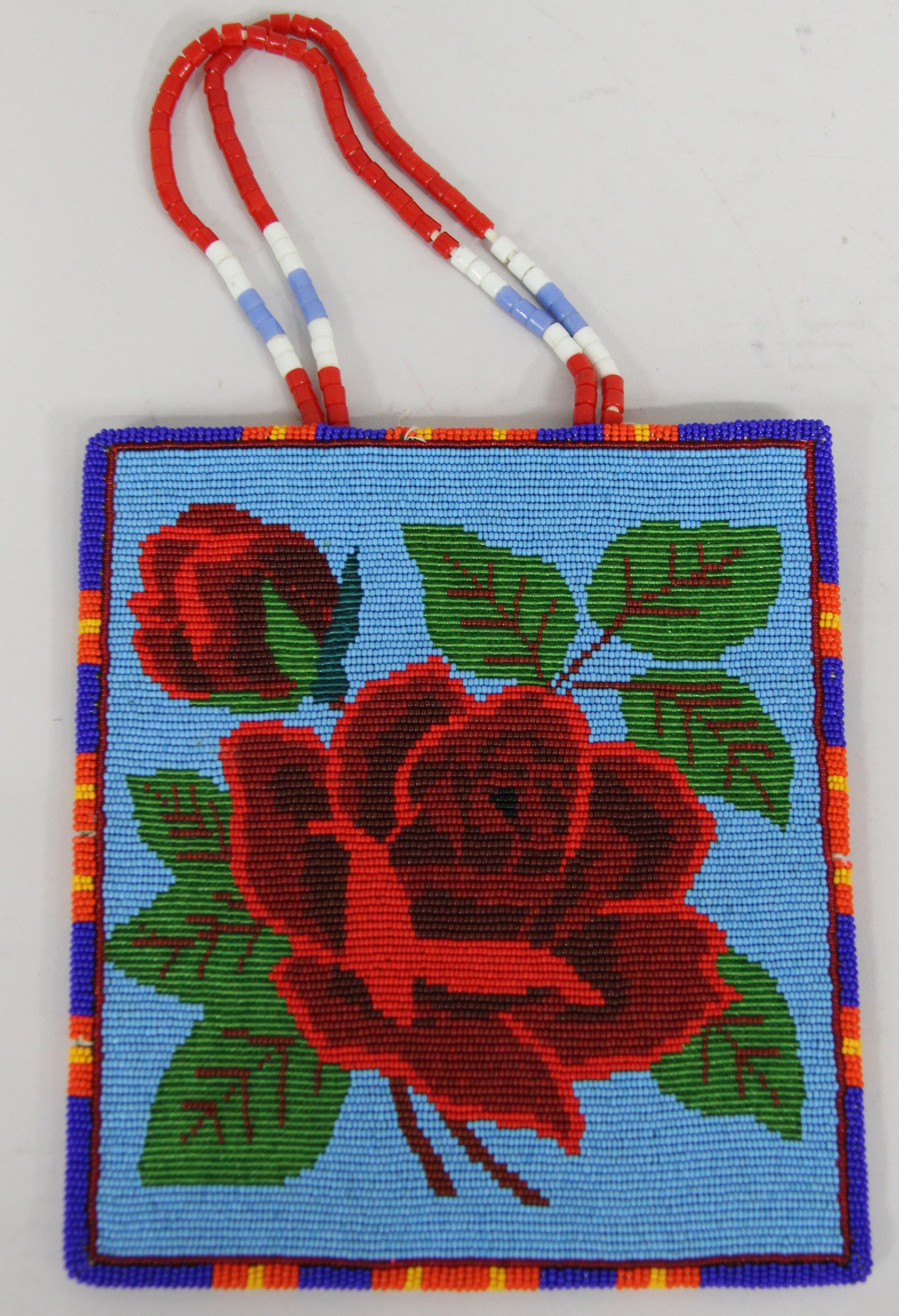 A blue beaded bag with a red rose floral pattern.