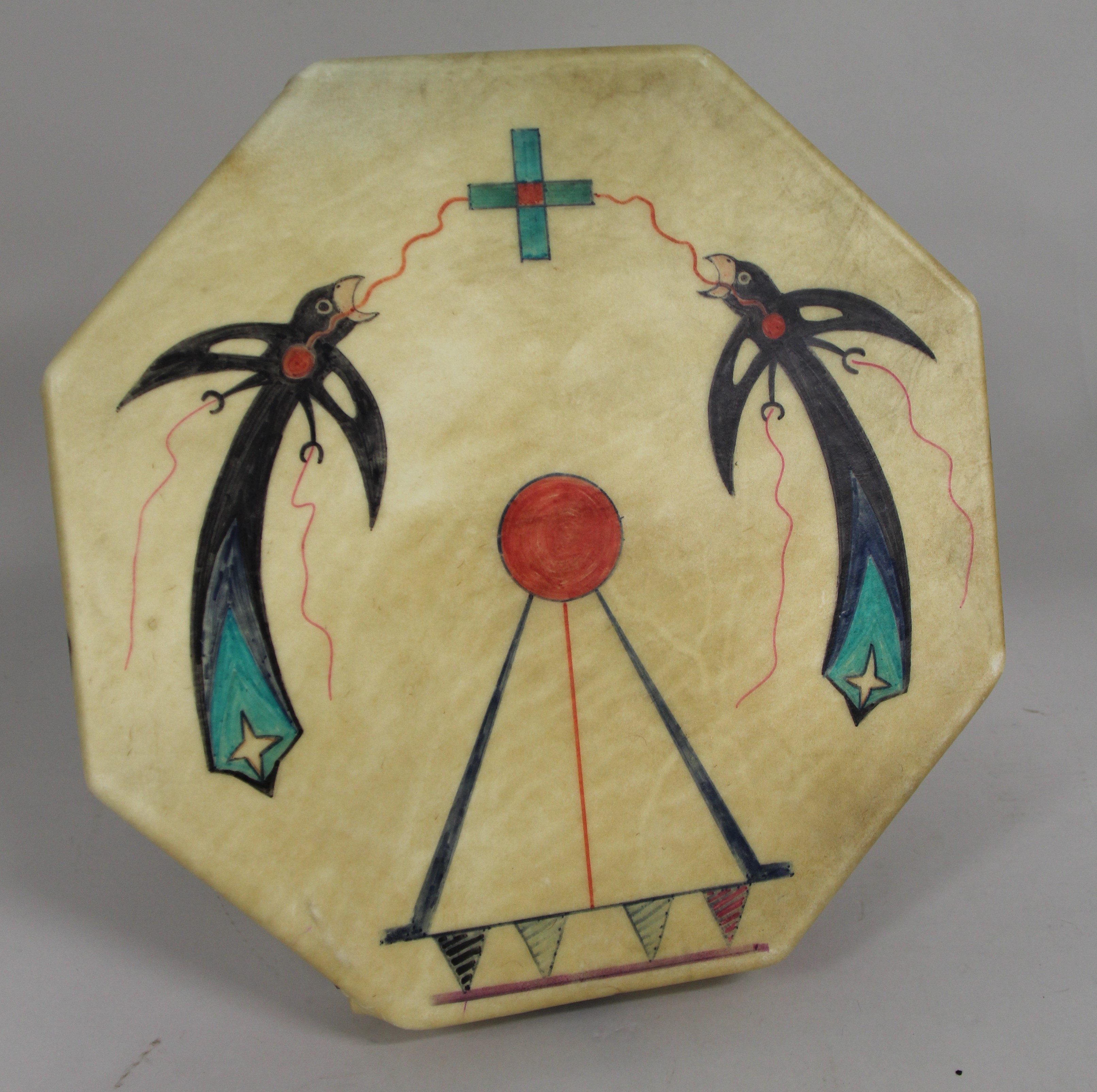 A raw-hide drum the shape of an octagon with two birds on each side