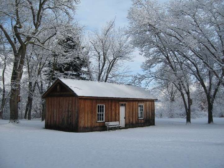 Winter picture of Agency Cabin Wood cabin in wooded area with snow on the ground