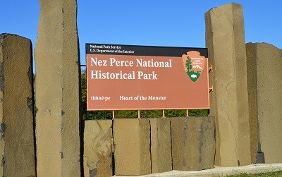 A sign with the National Park Service Arrowhead and text that reads "Nez Perce National Historical Park Heart of the Monster."