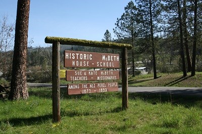 A brown wooden sign with the words 'Historic McBeth House - School' on it