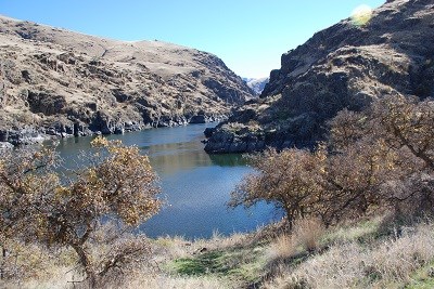 A river surrounded by rocky cliffs on a sunny day.