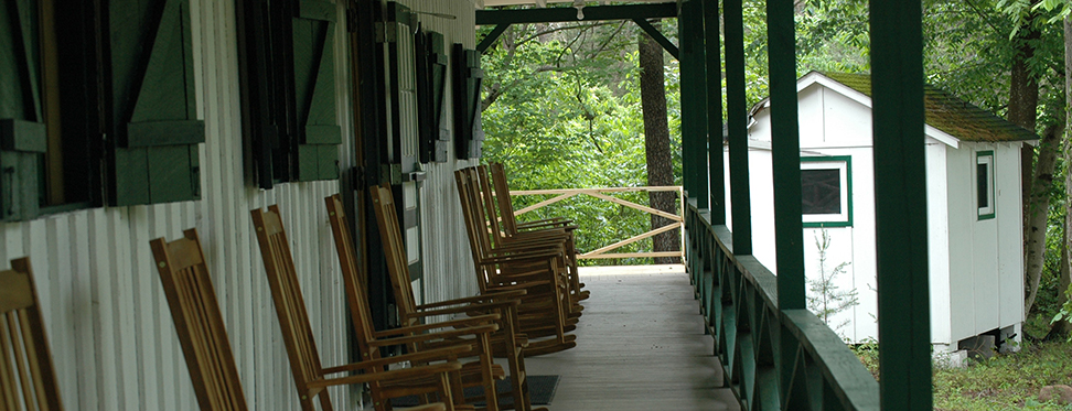 view of a long porch with rocking chairs