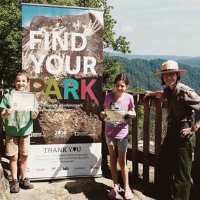 Ranger and kids by "Find Your Park" sign Ranger and kids by "Find Your Park" sign