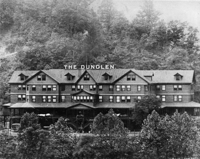 Photo of a Multi story wooden building with large latters on the roof that spell out "Dun Glen"