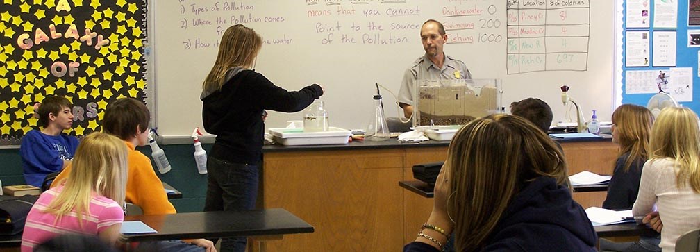 ranger doing science experiment with students in a classroom