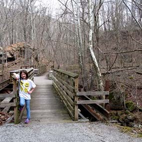 young girl standing at footbridge