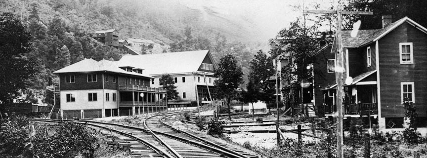 Historic photo of Quinnimont depot, railroad tracks, and houses.