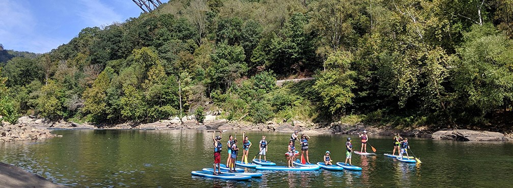 kids on stand up paddle boards on the river