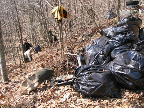 Workers clean up gargbage at dump site