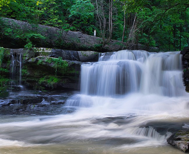 A wide waterfall flowing over a rocky dropoff