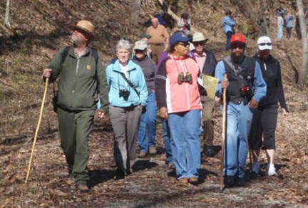 hiker and visitors hiking down a trail