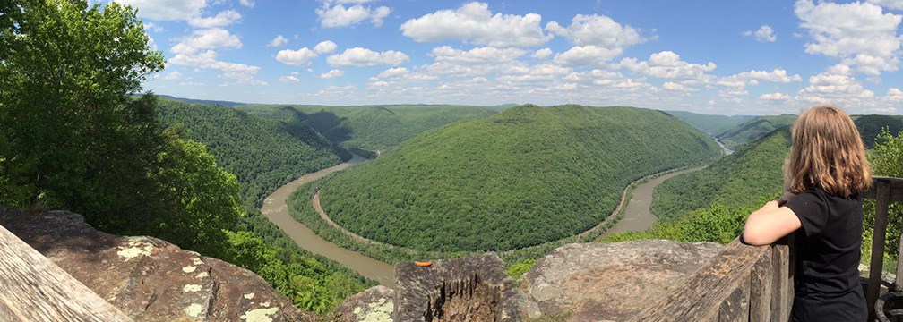 Girl looking out from viewpoint over gorge and river