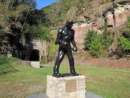 John Henry statue stands in front of a tunnel